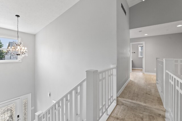 11226 Blackwalnut Pt, Indianapolis, IN 46236 - hall featuring an upstairs landing, a chandelier, a high ceiling, wood finished floors, and baseboards