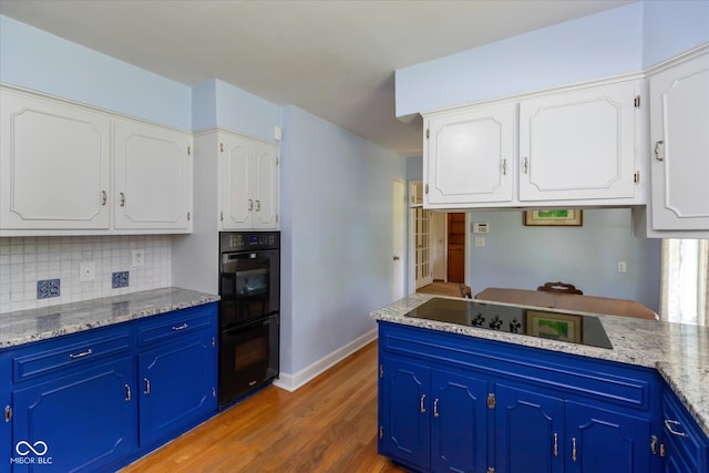 7401 Spring Mill Rd, Indianapolis, IN 46260 - kitchen with black appliances, wood finished floors, white cabinets, and decorative backsplash