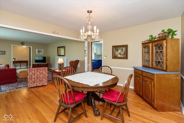 7401 Spring Mill Rd, Indianapolis, IN 46260 - dining room with light wood-type flooring, a chandelier, and baseboards