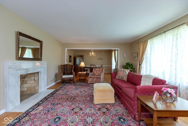 7401 Spring Mill Rd, Indianapolis, IN 46260 - living area featuring a chandelier, wood finished floors, a fireplace, and baseboards