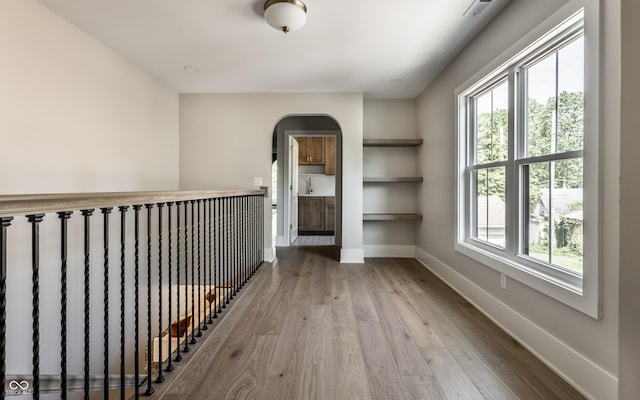 5682 Broadway St, Indianapolis, IN 46220 - hallway with wood finished floors, baseboards, a sink, and arched walkways