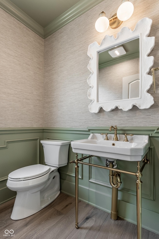 5682 Broadway St, Indianapolis, IN 46220 - half bathroom featuring wood finished floors, toilet, crown molding, and wainscoting