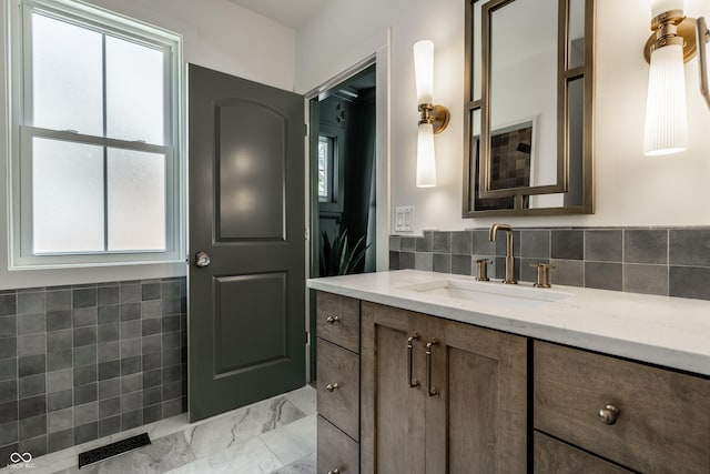 5682 Broadway St, Indianapolis, IN 46220 - bathroom featuring healthy amount of natural light, vanity, marble finish floors, and backsplash