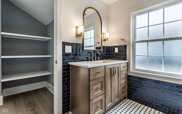 5682 Broadway St, Indianapolis, IN 46220 - bathroom featuring lofted ceiling, vanity, built in shelves, wood finished floors, and wainscoting