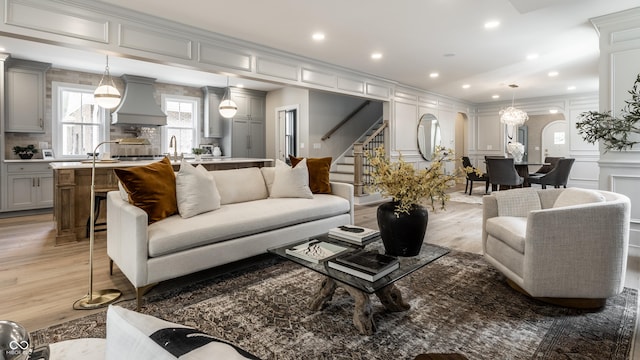 5682 Broadway St, Indianapolis, IN 46220 - living room with a decorative wall, light wood-style flooring, stairs, recessed lighting, and arched walkways