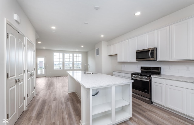 14515 Hanford Ln, Carmel, IN 46074 - kitchen with appliances with stainless steel finishes, a sink, light wood finished floors, white cabinets, and recessed lighting