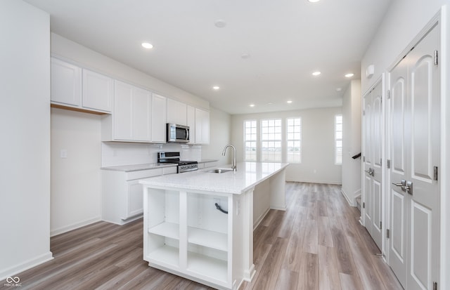 14515 Hanford Ln, Carmel, IN 46074 - kitchen featuring appliances with stainless steel finishes, a sink, white cabinetry, light wood finished floors, and recessed lighting