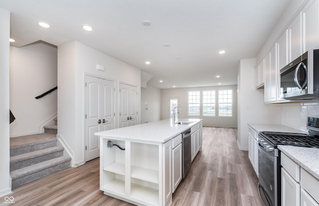 14515 Hanford Ln, Carmel, IN 46074 - kitchen featuring stainless steel appliances, a sink, white cabinets, light wood-style flooring, and open shelves