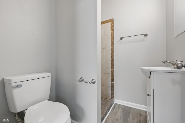 2030 Houston St, Indianapolis, IN 46218 - full bath with toilet, a tile shower, wood finished floors, vanity, and baseboards