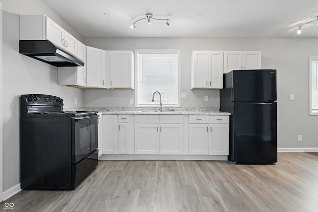 2030 Houston St, Indianapolis, IN 46218 - kitchen featuring black appliances, under cabinet range hood, a sink, rail lighting, and light wood-style floors