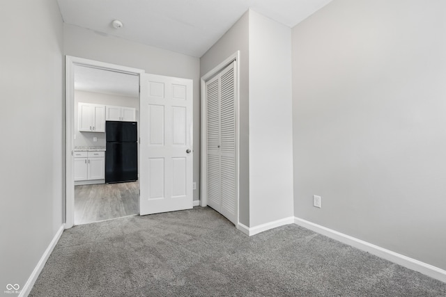 2030 Houston St, Indianapolis, IN 46218 - unfurnished bedroom featuring freestanding refrigerator, carpet floors, baseboards, and a closet