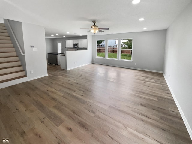 10366 Camby Xing, Fishers, IN 46038 - unfurnished living room featuring recessed lighting, a ceiling fan, stairway, wood finished floors, and baseboards