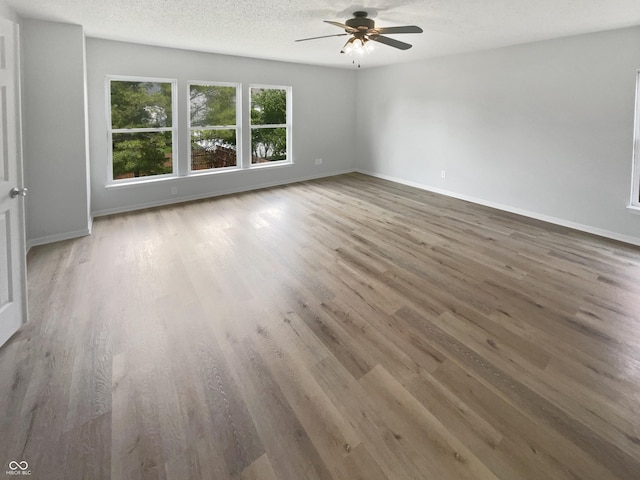 10366 Camby Xing, Fishers, IN 46038 - unfurnished room with ceiling fan, wood finished floors, baseboards, and a textured ceiling