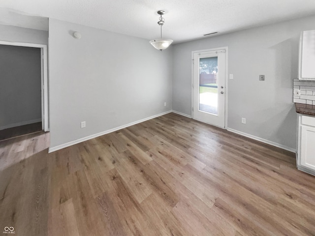 10366 Camby Xing, Fishers, IN 46038 - unfurnished dining area featuring wood finished floors, baseboards, and a textured ceiling