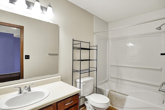 full bathroom featuring shower / bath combination, a textured wall, vanity, and toilet