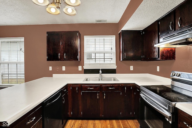 kitchen featuring stainless steel electric range, a textured ceiling, a sink, under cabinet range hood, and light countertops