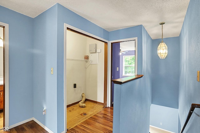 bathroom featuring wood finished floors, a textured ceiling, and baseboards