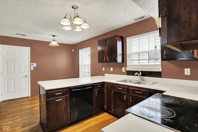 kitchen with dishwasher, a textured ceiling, a sink, light countertops, and a peninsula