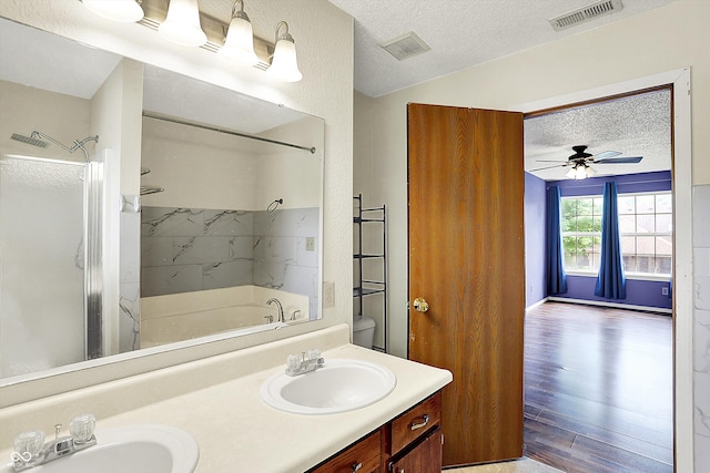 full bath with a textured ceiling, a shower, double vanity, wood finished floors, and a bathtub