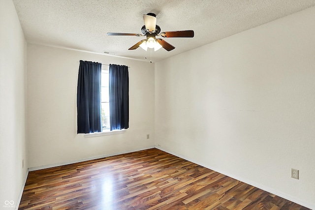 spare room with wood finished floors, a textured ceiling, and ceiling fan