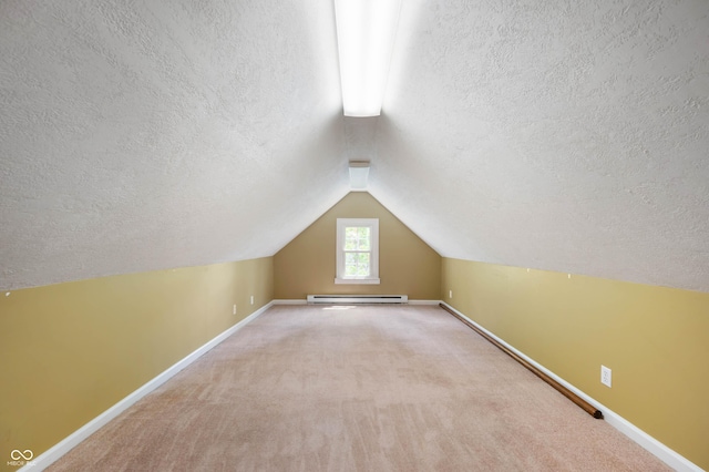 7910 N College Ave, Indianapolis, IN 46240 - additional living space featuring a textured ceiling, baseboards, vaulted ceiling, a baseboard radiator, and carpet floors
