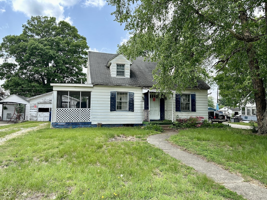 3060 N 16th St, Terre Haute, IN 47804 - cape cod-style house featuring a front lawn, a sunroom, and roof with shingles