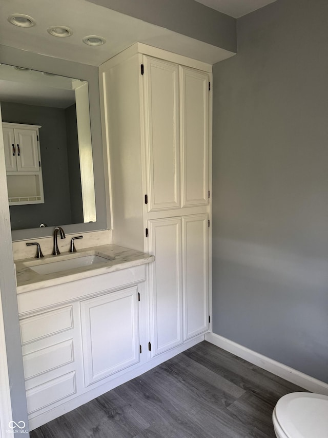 3342 Foltz St, Indianapolis, IN 46221 - half bathroom with baseboards, wood finished floors, vanity, toilet, and recessed lighting