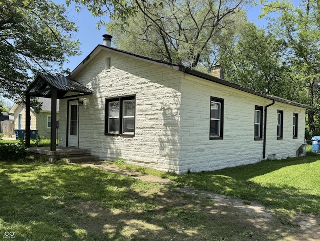 3342 Foltz St, Indianapolis, IN 46221 - view of property exterior with stone siding, a chimney, and a lawn