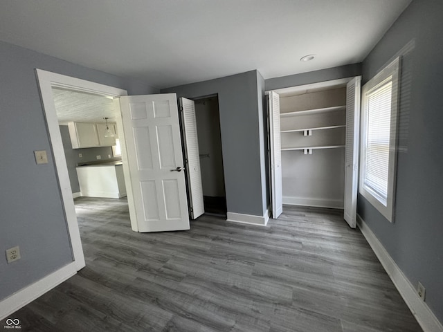 3342 Foltz St, Indianapolis, IN 46221 - unfurnished bedroom with baseboards and dark wood finished floors