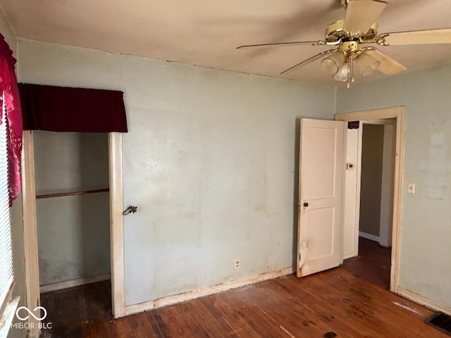 unfurnished bedroom with wood finished floors, baseboards, and a ceiling fan