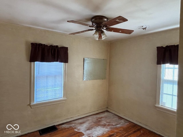 unfurnished room featuring a ceiling fan, wood finished floors, and baseboards