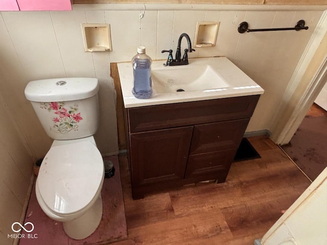 bathroom with wood finished floors, vanity, and toilet