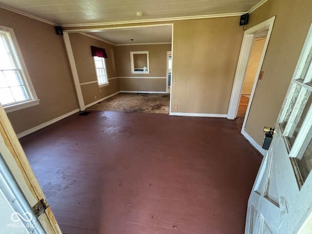 spare room with crown molding and baseboards