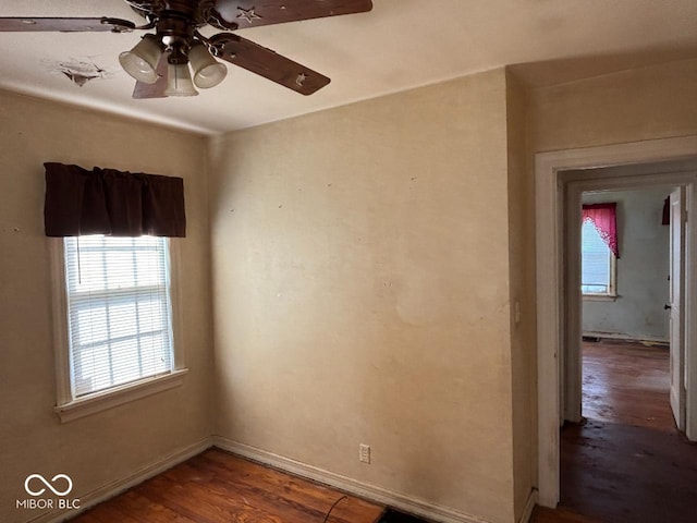 spare room featuring wood finished floors, ceiling fan, and baseboards