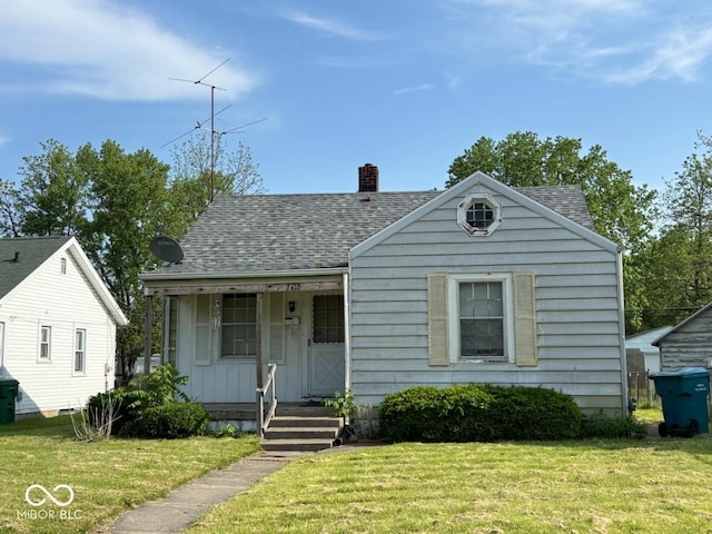 bungalow-style house with covered porch, a front yard, and a shingled roof