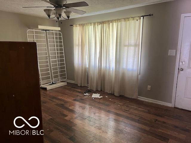 825 W Auman Dr, Carmel, IN 46032 - spare room featuring a ceiling fan, dark wood-type flooring, baseboards, and a textured ceiling