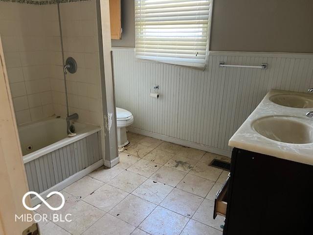 825 W Auman Dr, Carmel, IN 46032 - full bathroom featuring wainscoting, tile patterned flooring, toilet, double vanity, and shower / tub combination