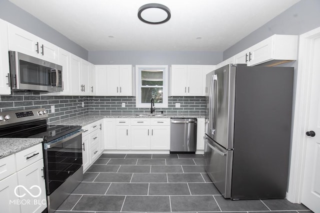6805 N Base Rd, North Vernon, IN 47265 - kitchen featuring appliances with stainless steel finishes, a sink, backsplash, and white cabinetry
