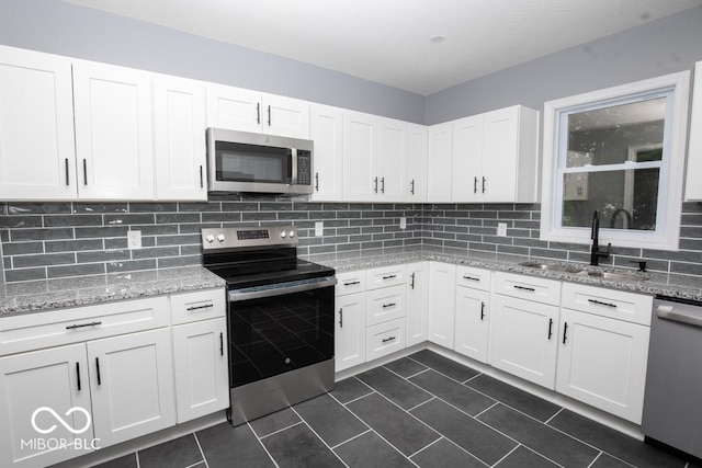 6805 N Base Rd, North Vernon, IN 47265 - kitchen featuring appliances with stainless steel finishes, a sink, tasteful backsplash, white cabinets, and dark tile patterned flooring