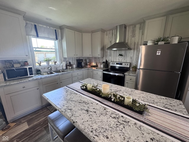 216 E Wabash St, Wingate, IN 47994 - kitchen featuring stainless steel appliances, wall chimney range hood, a sink, dark wood-style floors, and decorative backsplash