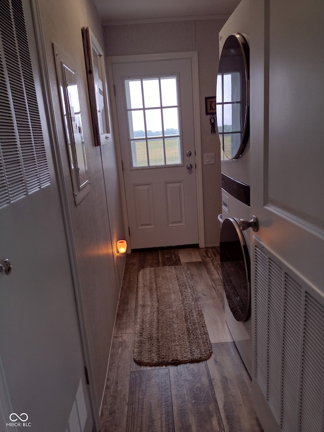 216 E Wabash St, Wingate, IN 47994 - washroom with stacked washing machine and dryer, a heating unit, and wood finished floors