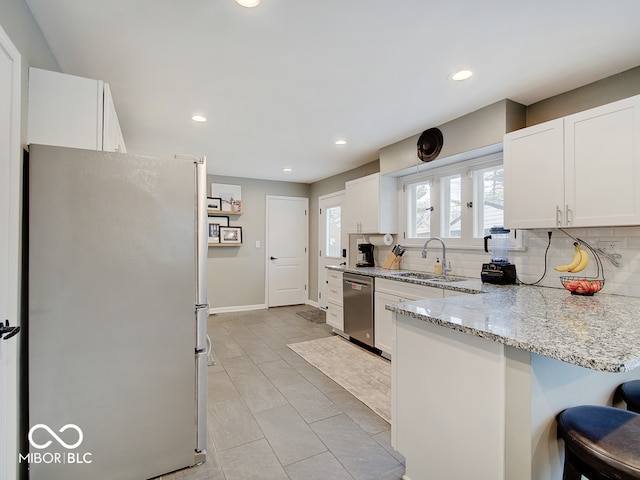 3659 Watson Rd, Indianapolis, IN 46205 - kitchen featuring stainless steel appliances, a sink, backsplash, light stone countertops, and recessed lighting