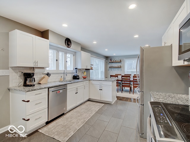 3659 Watson Rd, Indianapolis, IN 46205 - kitchen with stainless steel appliances, a sink, decorative backsplash, white cabinets, and recessed lighting