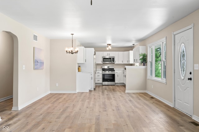 kitchen with stainless steel appliances, light wood-style flooring, baseboards, white cabinetry, and light countertops