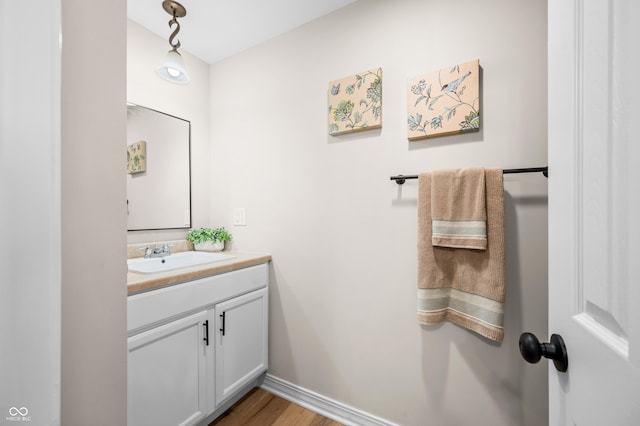 bathroom featuring vanity, wood finished floors, and baseboards