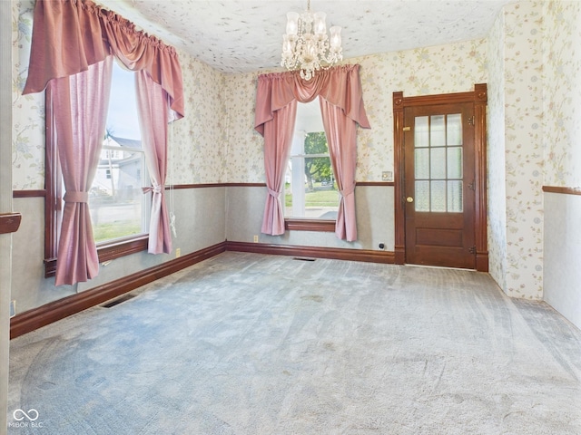 814 Walnut St, Anderson, IN 46012 - carpeted empty room featuring wallpapered walls and a chandelier
