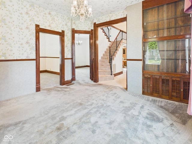 814 Walnut St, Anderson, IN 46012 - unfurnished room featuring a chandelier, wallpapered walls, stairway, and carpet flooring