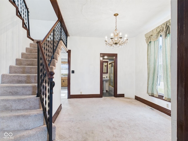 814 Walnut St, Anderson, IN 46012 - stairs with carpet floors, baseboards, and a chandelier
