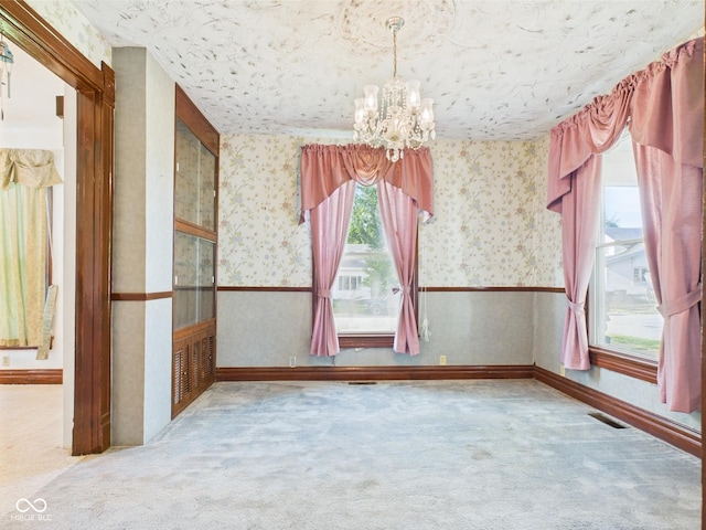 814 Walnut St, Anderson, IN 46012 - empty room with a chandelier, carpet, wallpapered walls, and plenty of natural light