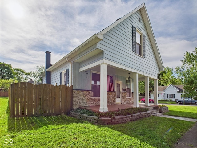814 Walnut St, Anderson, IN 46012 - view of front facade featuring covered porch, stone siding, and a chimney